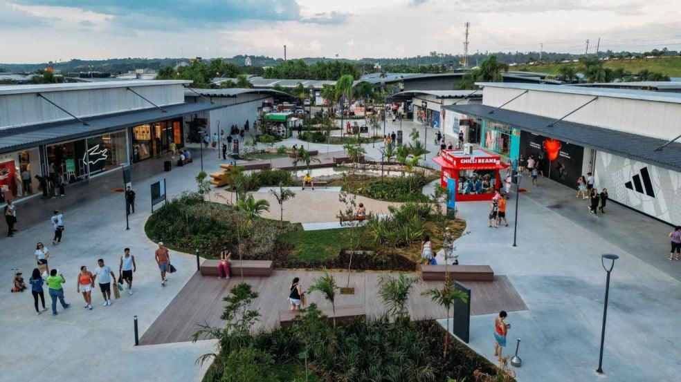 Vista aérea do Outlet Premium São Paulo em Itupeva com visitantes caminhando entre lojas e área ajardinada.