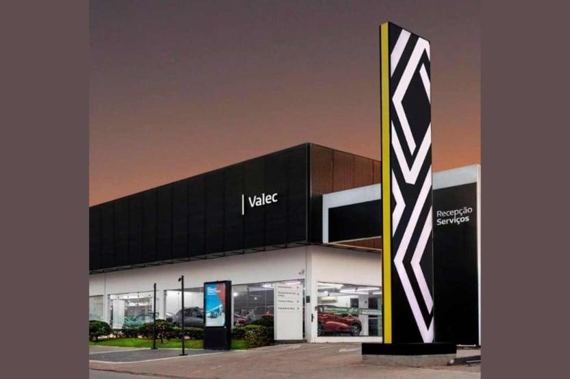 Fachada da concessionária Valec Renault com iluminação ao entardecer, destacando a entrada de serviços e a identidade visual da marca.