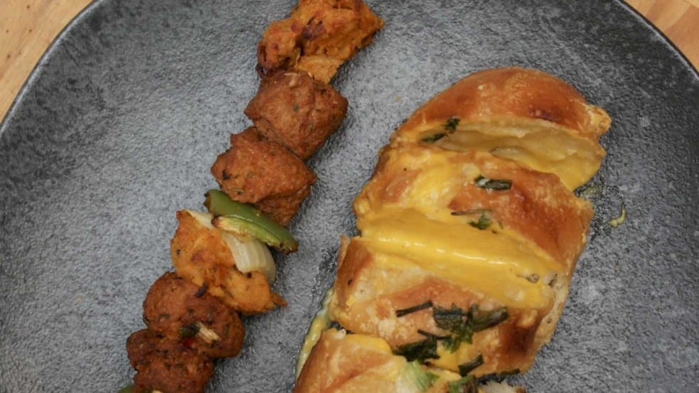 Espetinho vegano com legumes e pão de alho com queijo vegetal.