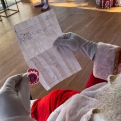 Papai Noel segura cartinha infantil e chupeta deixada como pedido simb&oacute;lico de Natal na Casa da ACE Jundia&iacute;.