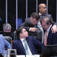 Deputados reunidos no plenário da Câmara conversam e trocam cumprimentos durante a sessão, com alguns sentados diante dos computadores e outros fazendo articulações de pé atrás das cadeiras.