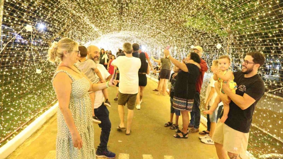 Pessoas caminhando e tirando fotos dentro de um túnel iluminado por milhares de luzes douradas no Natal Encantado de Itupeva. Pessoas caminhando e tirando fotos dentro de um túnel iluminado por milhares de luzes douradas no Natal Encantado de Itupeva.