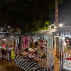 Estandes do Jundia&iacute; Feito &agrave; M&atilde;o com artesanato natalino exposto em barracas iluminadas durante a noite, com pessoas circulando em clima de Natal em Jundia&iacute;.