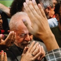 Presidente Lula participa de momento de ora&ccedil;&atilde;o coletiva, cercado por apoiadores com m&atilde;os erguidas durante encontro religioso.