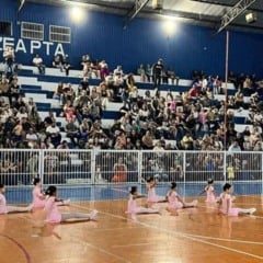 Crianças do balé se apresentam no centro da quadra diante do público.