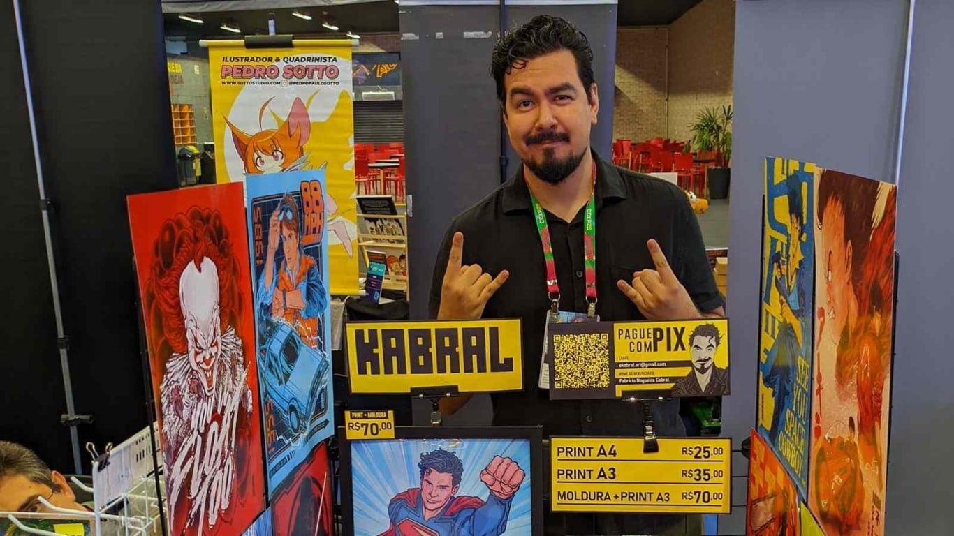 Ilustrador Fabrício Kabral posa em seu estande no Artists’ Valley da CCXP 2025, com artes e quadrinhos expostos. Ilustrador Fabrício Kabral posa em seu estande no Artists’ Valley da CCXP 2025, com artes e quadrinhos expostos.