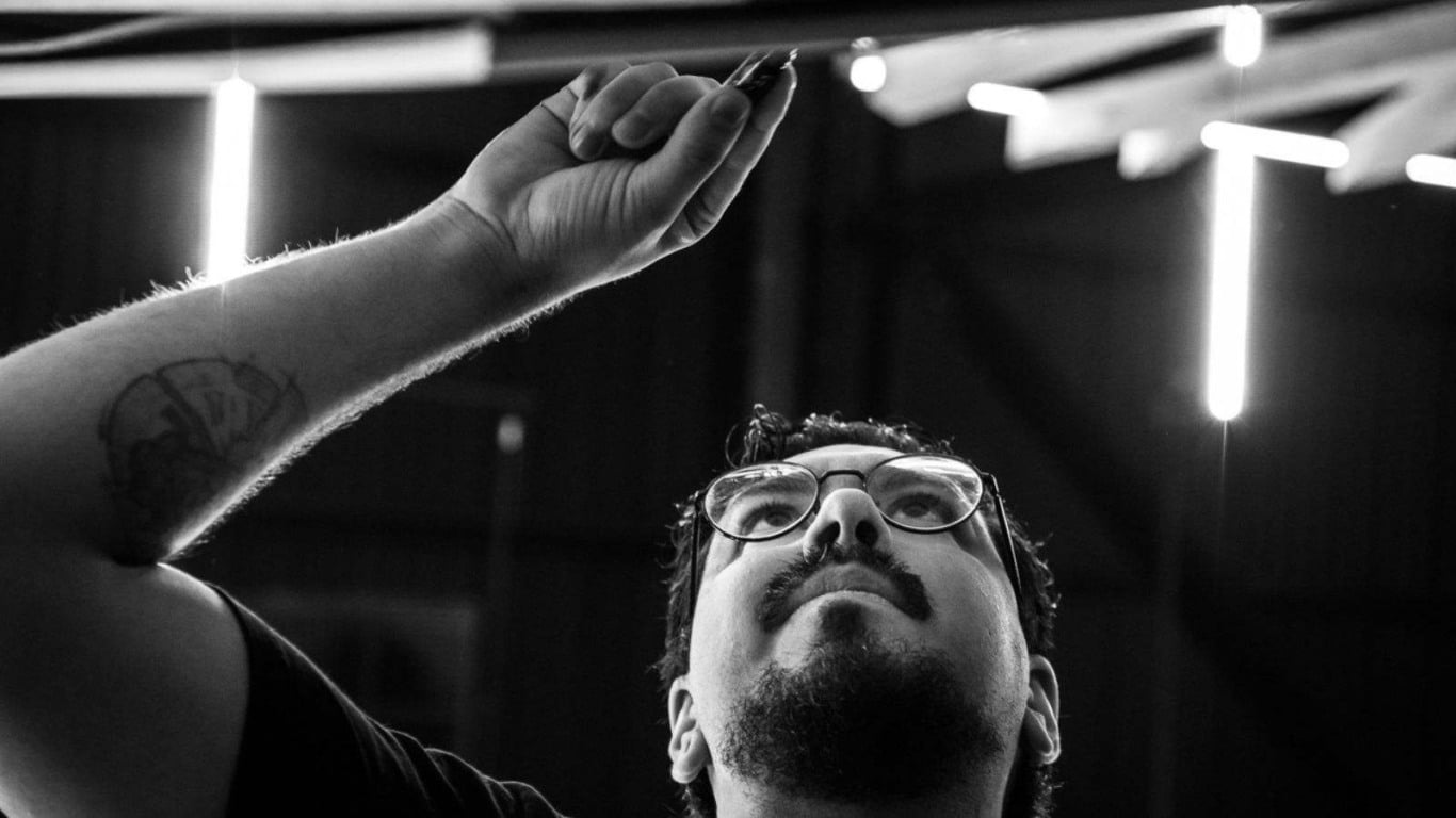 Ilustrador Fabrício Kabral aparece em close, com punho erguido, em foto em preto e branco durante a CCXP 2025. Ilustrador Fabrício Kabral aparece em close, com punho erguido, em foto em preto e branco durante a CCXP 2025.