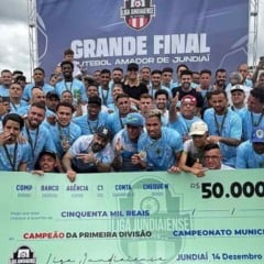Jogadores e comiss&atilde;o t&eacute;cnica do Vila Marlene comemoram o t&iacute;tulo do Campeonato Amador de Jundia&iacute; segurando cheque simb&oacute;lico de R$ 50 mil durante a grande final no Dal Santo.