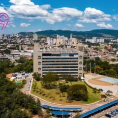 Imagem aérea do Paço Municipal de Jundiaí com a cidade ao fundo, prédios altos, áreas verdes e a logomarca dos 369 anos no canto esquerdo.