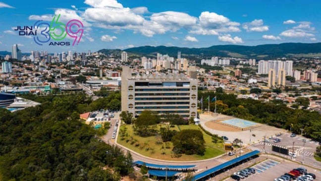 Imagem aérea do Paço Municipal de Jundiaí com a cidade ao fundo, prédios altos, áreas verdes e a logomarca dos 369 anos no canto esquerdo.