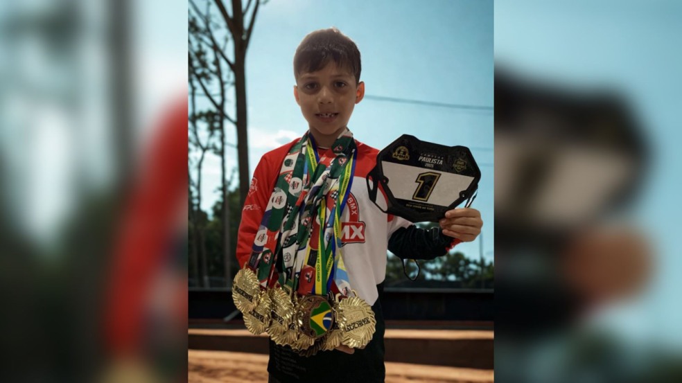 Lucca Bernardes, 7 anos, segura placa número 1 e exibe várias medalhas de ouro no pescoço, posando com orgulho após conquistas no BMX. Lucca Bernardes, 7 anos, segura placa número 1 e exibe várias medalhas de ouro no pescoço, posando com orgulho após conquistas no BMX.