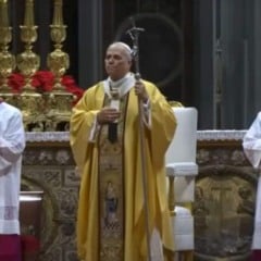 Papa Le&atilde;o 14 celebra a Missa do Galo na Bas&iacute;lica de S&atilde;o Pedro, no Vaticano, usando vestes douradas e acompanhado por dois cl&eacute;rigos diante de um altar decorado com flores vermelhas e casti&ccedil;ais dourados.