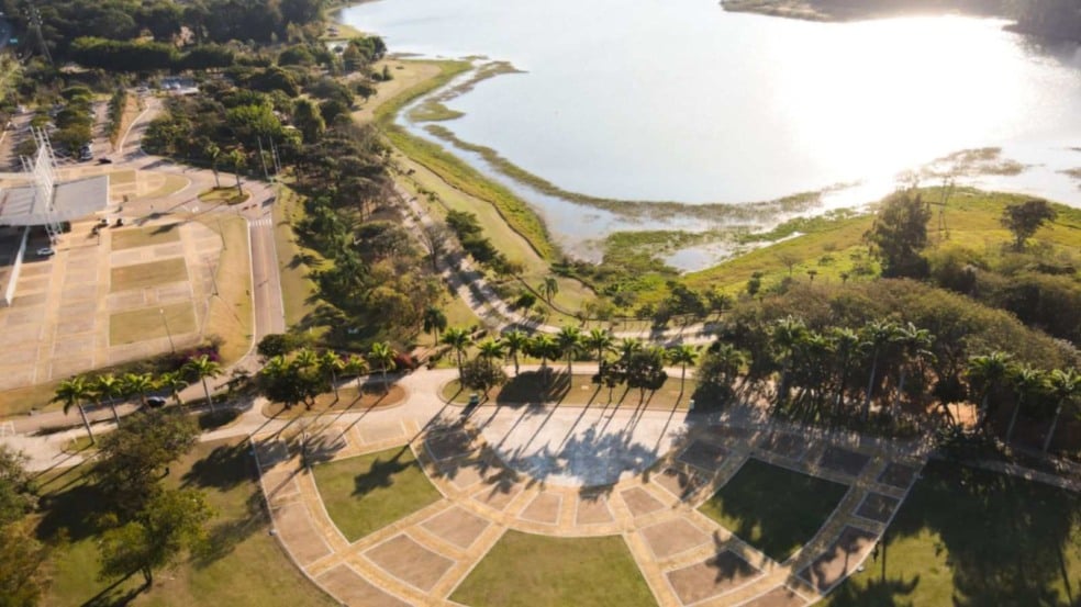Imagem aérea do Parque da Cidade, em Jundiaí, mostrando a represa iluminada pelo sol, áreas verdes, caminhos arborizados e estruturas do parque ao lado. Imagem aérea do Parque da Cidade, em Jundiaí, mostrando a represa iluminada pelo sol, áreas verdes, caminhos arborizados e estruturas do parque ao lado.