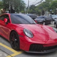 Porsche vermelho apreendido pela Polícia Civil estacionado em área do Deic, com outros veículos ao fundo.