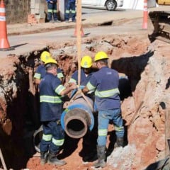 Trabalhadores da DAE Jundia&iacute; instalam tubula&ccedil;&atilde;o de saneamento em obra urbana.