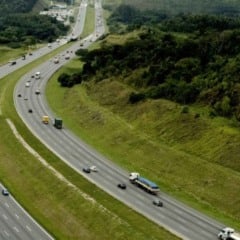 Vista a&eacute;rea da Rodovia dos Bandeirantes com v&aacute;rias faixas, ve&iacute;culos em movimento e &aacute;reas verdes ao redor, destacando infraestrutura moderna e tr&aacute;fego fluido.