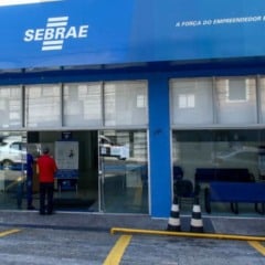 Fachada da unidade do Sebrae-SP com portas de vidro, pessoas entrando no prédio e o logotipo do Sebrae destacado na parte superior azul.