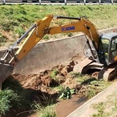Escavadeira faz desassoreamento de c&oacute;rrego em Jundia&iacute;, removendo lama e vegeta&ccedil;&atilde;o como parte de a&ccedil;&atilde;o de preven&ccedil;&atilde;o a enchentes.