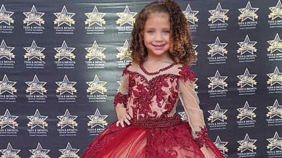 Menina de 4 anos, Pietra Hasten, usa vestido vermelho bordado e sorri diante do painel do concurso Miss São Paulo Teen Infantil. Menina de 4 anos, Pietra Hasten, usa vestido vermelho bordado e sorri diante do painel do concurso Miss São Paulo Teen Infantil.