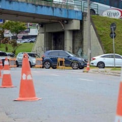 Cones e barreiras bloqueiam trecho de avenida sob viaduto, com carros parados em fila durante interdi&ccedil;&atilde;o para obras de saneamento em V&aacute;rzea Paulista.