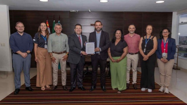 Grupo de autoridades de Jundiaí e do Detran-SP alinhados em pé para foto oficial; ao centro, o prefeito Gustavo Martinelli e Frederico Pierotti Arantes seguram o documento de adesão da cidade ao Sistran-SP.