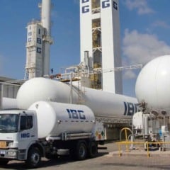 Planta industrial da IBG com tanques de gases industriais, torres met&aacute;licas e caminh&atilde;o-tanque da empresa estacionado no local.