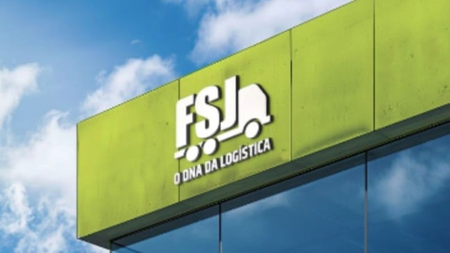 Fachada da FSJ Logística com logotipo da empresa em painel verde e símbolo de caminhão, em prédio moderno do setor de transporte e logística.