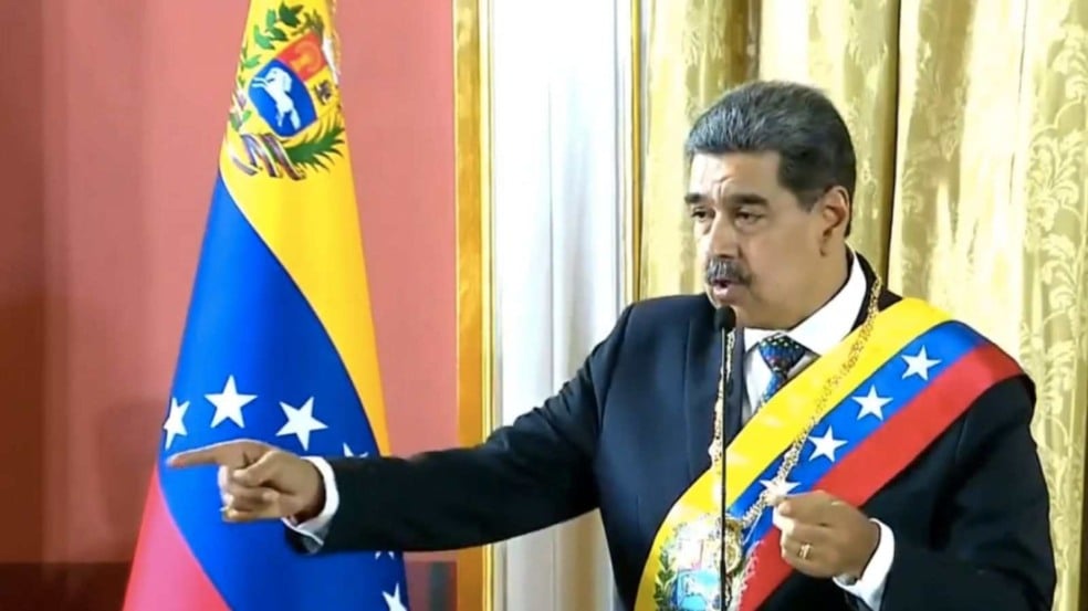 Nicolás Maduro discursa em cerimônia oficial, usando faixa presidencial da Venezuela e gesticulando diante da bandeira nacional. Nicolás Maduro discursa em cerimônia oficial, usando faixa presidencial da Venezuela e gesticulando diante da bandeira nacional.