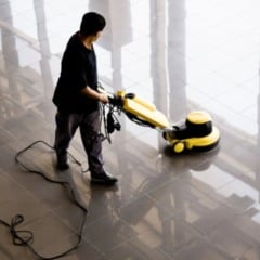 Auxiliar de limpeza utiliza equipamento industrial para higieniza&ccedil;&atilde;o de piso em &aacute;rea interna de grande circula&ccedil;&atilde;o.