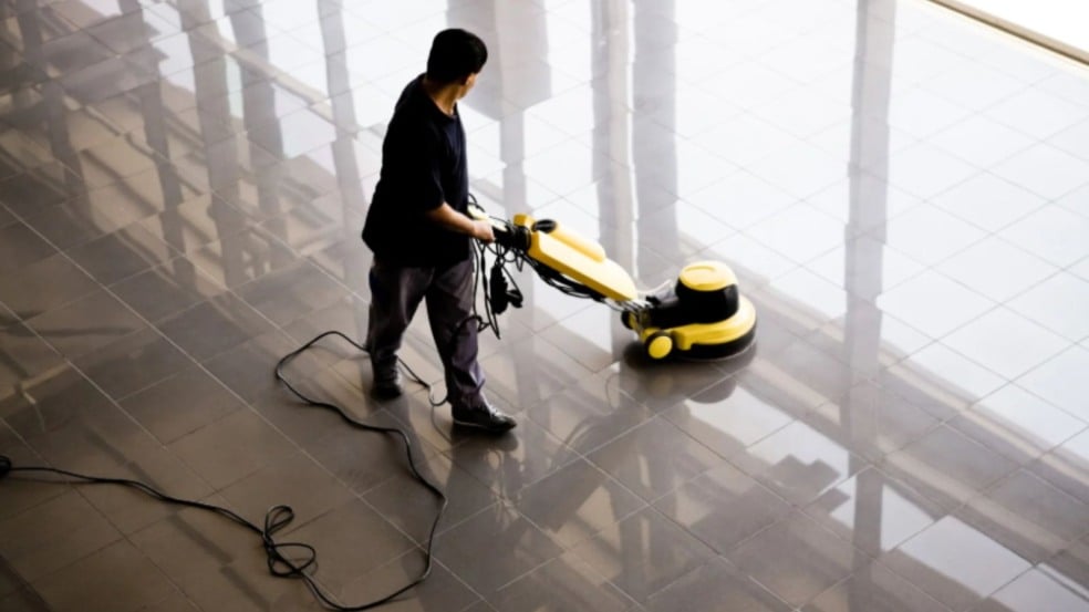 Auxiliar de limpeza utiliza equipamento industrial para higienização de piso em área interna de grande circulação. Auxiliar de limpeza utiliza equipamento industrial para higienização de piso em área interna de grande circulação.