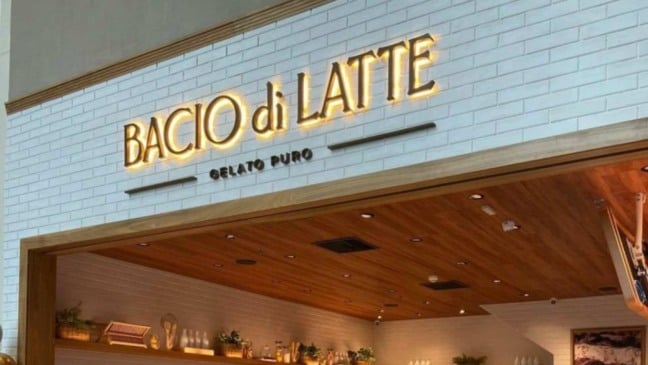 Fachada da Bacio di Latte com letreiro iluminado e ambiente moderno, destacando a identidade visual da gelateria italiana.