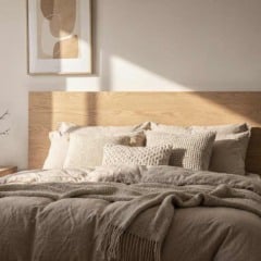 Cabeceira de cama em madeira clara estilo DIY, com cama de casal, roupas de cama neutras e ilumina&ccedil;&atilde;o natural suave em quarto aconchegante.