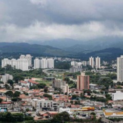 Vista de Jundia&iacute; com pr&eacute;dios residenciais e a Serra do Japi ao fundo sob c&eacute;u nublado e carregado, indicando tempo inst&aacute;vel e possibilidade de chuva.
