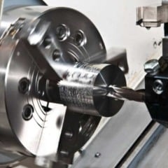 Torno CNC em opera&ccedil;&atilde;o usinando pe&ccedil;a met&aacute;lica cil&iacute;ndrica em ambiente industrial.