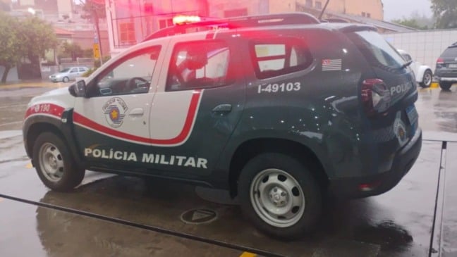 Viatura da Polícia Militar do Estado de São Paulo estacionada em via urbana de Jundiaí, com giroflex ligado, durante atendimento de ocorrência na cidade.