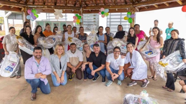 Grupo de gestantes e representantes do Fundo Social de Jundiaí posam com kits de maternidade durante entrega do projeto Colo de Mãe na UBS Fazenda Grande.
