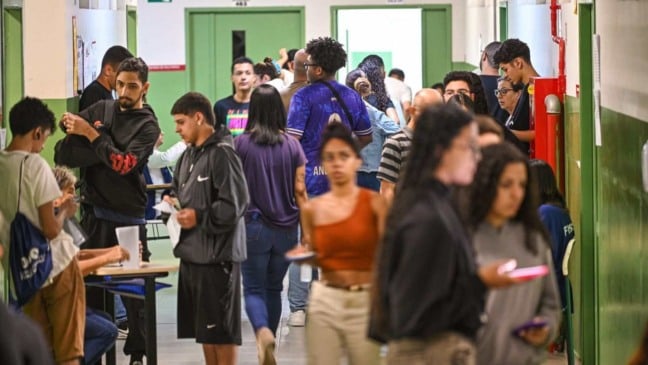 Estudantes circulam e aguardam atendimento em corredor de uma unidade da Fatec durante período de matrícula.