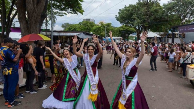 Corte da Uva desfila e acena para o público durante a Festa da Uva de Jundiaí, com visitantes acompanhando o evento no Parque da Uva.