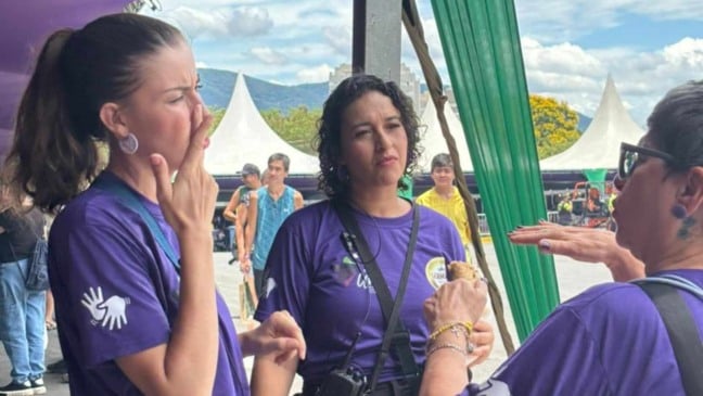 Intérpretes de Libras atendem visitantes durante a Festa da Uva, garantindo comunicação acessível no evento.