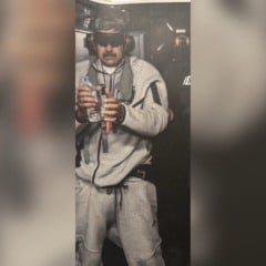 Nicol&aacute;s Maduro vendado e aparentemente algemado em navio dos EUA ap&oacute;s captura, segurando garrafa de &aacute;gua