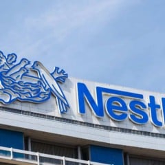Fachada do pr&eacute;dio da Nestl&eacute; com logotipo azul e s&iacute;mbolo do ninho em destaque.
