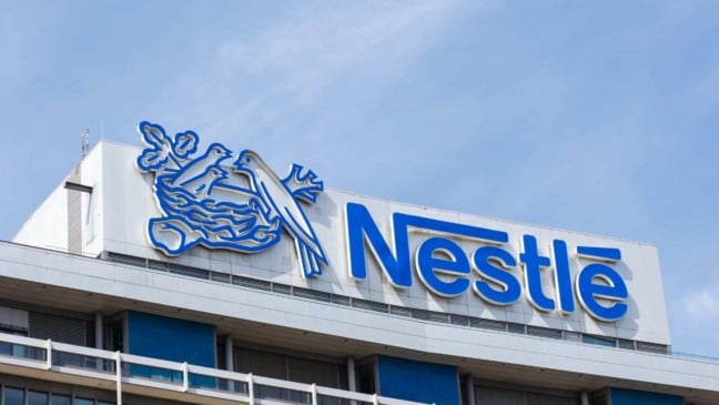 Fachada do prédio da Nestlé com logotipo azul e símbolo do ninho em destaque.
