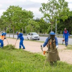 Equipes da Prefeitura de Jundia&iacute; realizam ro&ccedil;agem e manuten&ccedil;&atilde;o de &aacute;rea verde &agrave;s margens de uma via urbana, utilizando ro&ccedil;adeiras e equipamentos de prote&ccedil;&atilde;o.