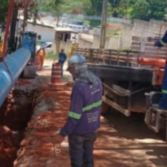 Trabalhadores instalam adutora de grande porte em obra de amplia&ccedil;&atilde;o do sistema de abastecimento de &aacute;gua, com uso de caminh&atilde;o e equipamentos de seguran&ccedil;a.