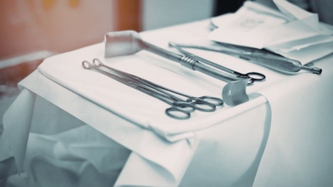 Instrumentos cirúrgicos sobre mesa indicam possível caso de pinça esquecida em hospital de João Pinheiro.