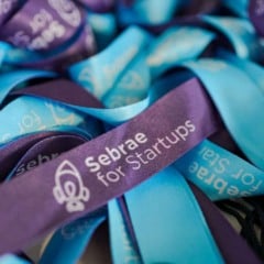 Cord&otilde;es promocionais azuis e roxos com a marca Sebrae for Startups, usados em eventos de empreendedorismo e inova&ccedil;&atilde;o.