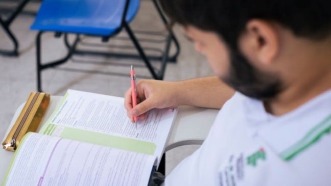 Estudante faz prova escrita em sala de aula, representando o acesso ao ensino superior por meio do Sisu.