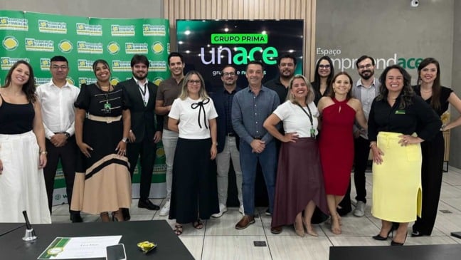 Integrantes da nova liderança do Unace – Grupo Prima posam para foto durante cerimônia de posse na Associação Comercial Empresarial de Jundiaí, em frente a painel institucional da ACE e do Unace.