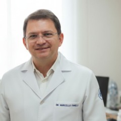 Dr. Marcelo Fanelli, oncologista da Faculdade de Medicina de Jundia&iacute;, em consult&oacute;rio m&eacute;dico vestindo jaleco branco.
