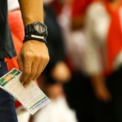 Homem segurando um bilhete da Mega-Sena